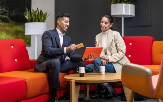 Circle K employee explaining terms and conditions to a woman on his tablet in a Circle K office